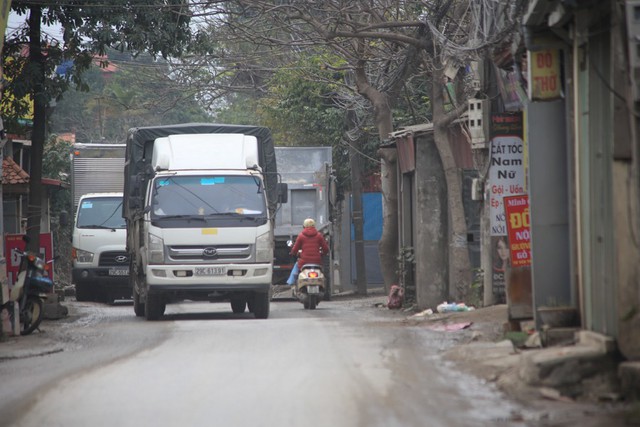 Con đường đau khổ ở Hà Nội bị cày nát, bụi vây kín nhà dân bởi hàng nghìn lượt xe siêu trọng tải mỗi ngày - Ảnh 1.
