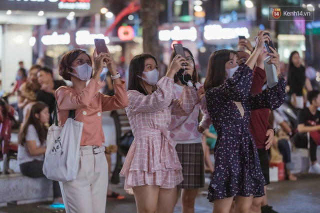 Chùm ảnh: Phố đi bộ Nguyễn Huệ vẫn đông kín người giữa những ngày tâm điểm dịch virus corona, một số người phớt lờ việc đeo khẩu trang phòng bệnh - Ảnh 7.
