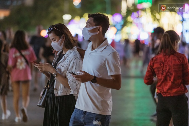 Chùm ảnh: Phố đi bộ Nguyễn Huệ vẫn đông kín người giữa những ngày tâm điểm dịch virus corona, một số người phớt lờ việc đeo khẩu trang phòng bệnh - Ảnh 11.