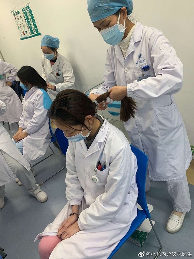 Phải cắt tóc, cạo đầu, mặc tã người lớn, ngủ trên sàn...: 30 bức ảnh chân thực nhất về tình cảnh của nhân viên y tế tại ‘ổ dịch’ Vũ Hán - Ảnh 1.