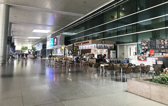 Người dân mặc đồ bảo hộ kín mít ra sân bay, ga quốc tế Tân Sơn Nhất hoang vắng lạ thường - Ảnh 3.