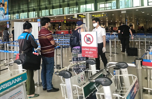 Người dân mặc đồ bảo hộ kín mít ra sân bay, ga quốc tế Tân Sơn Nhất hoang vắng lạ thường - Ảnh 6.