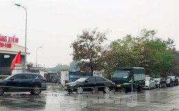 Người dân xếp hàng dưới mưa chờ đăng kiểm ô tô tại Hà Nội