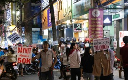 Nhiều nhân viên cửa hàng thời trang ở Sài Gòn cầm bảng giá tràn ra đường chào mời khách dịp cận Tết