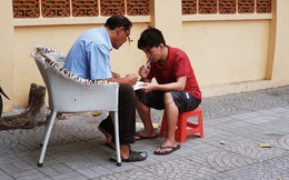 "Lớp học" đáng yêu trên vỉa hè: Một bác bảo vệ vừa giữ xe vừa dạy chữ cho cậu nhóc bán hàng rong ở Sài Gòn