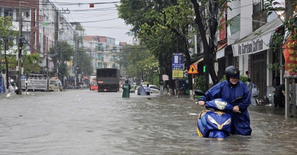 Phố biển ngập sau mưa lớn, người dân Nha Trang bì bõm đi làm, cõng con đi học