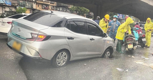 Taxi bất ngờ bị tụt bánh xuống cống trên phố Khuất Duy Tiến